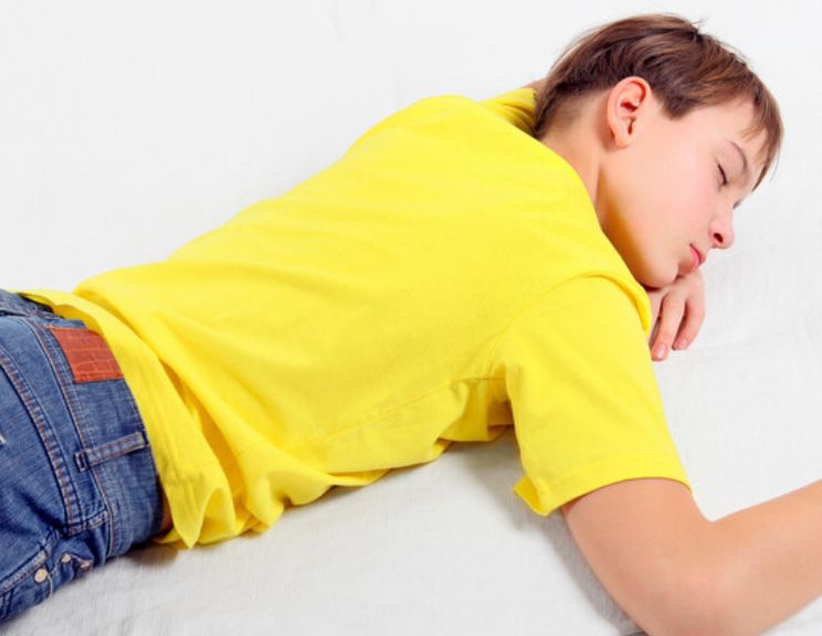 teenage in yellow shirt on bed